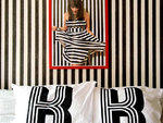 This portrait of Kreth (framed in red, of course) was taken by photographer Jamie Sanford (jamiesanford.com) and hangs above her bed. "It's meta---it's me standing in front of that wall on that wall," she says. Her bedding includes these pillows, screenpr