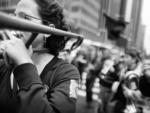 A group of protesters, including a marching band, crossed West 42nd Street as it enters Bryant Park.