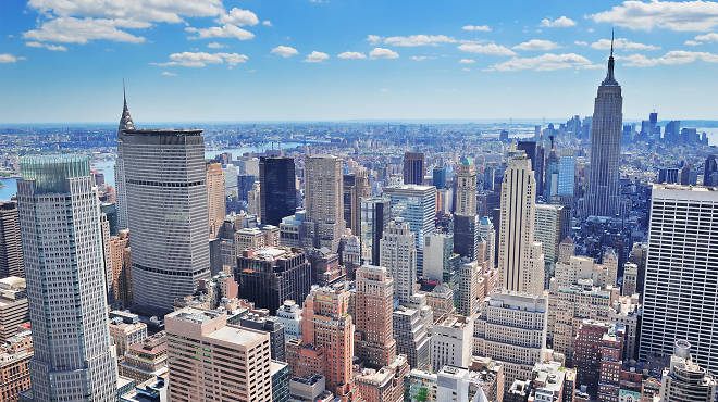 New York City Manhattan midtown aerial panorama view with skyscrapers and blue sky in the day.