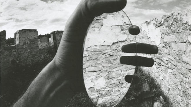 Joseph Jachna; Door County, Wisconsin (hand holding circular mirror, reflecting stone wall); 1970.