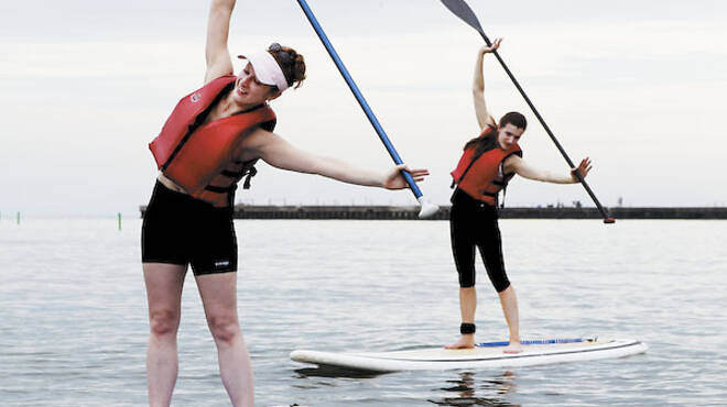 Chicago 7/16/11Instructor Jenna Zaffino, left, leads a paddleboard pilates class at Montrose Avenue Beach in Chicago.