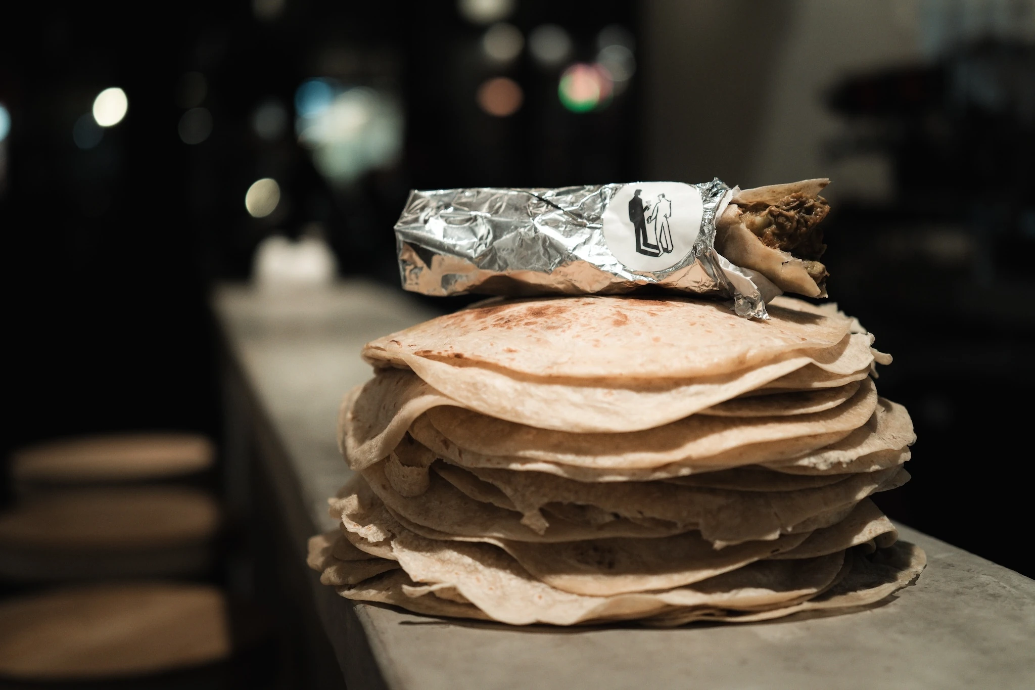 A stack of tortillas with a burrito on top