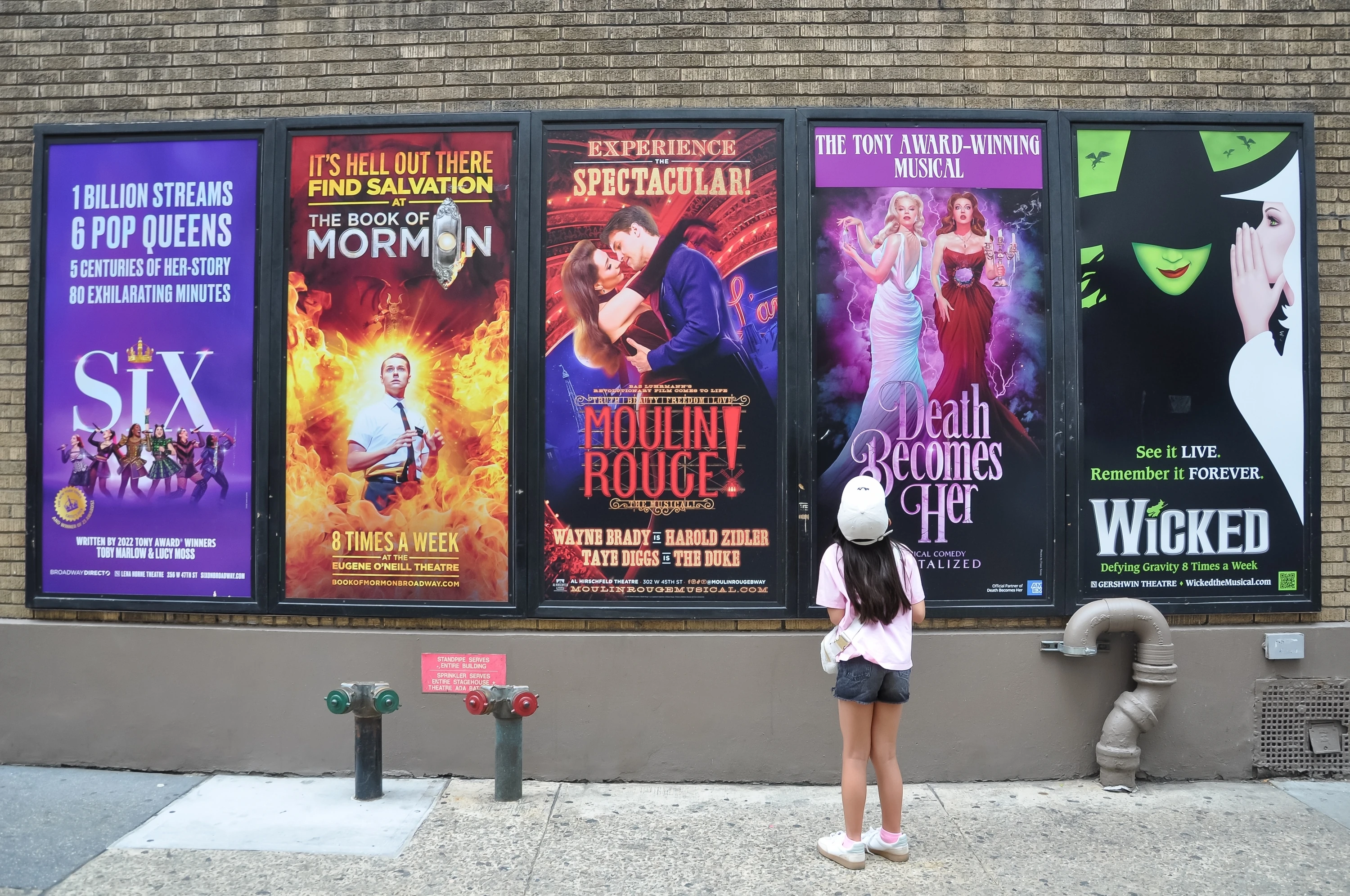 Young theater fan looking at Broadway ads