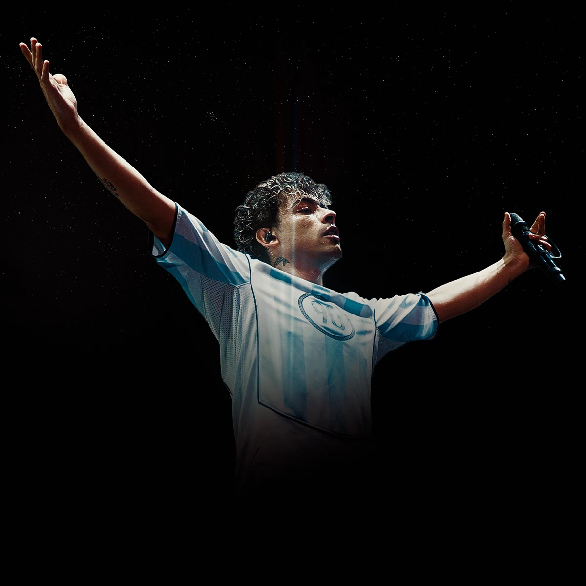 Trueno actuando sobre el escenario en un concierto con los brazos abiertos y viste la camiseta de la selecci&oacute;n argentina