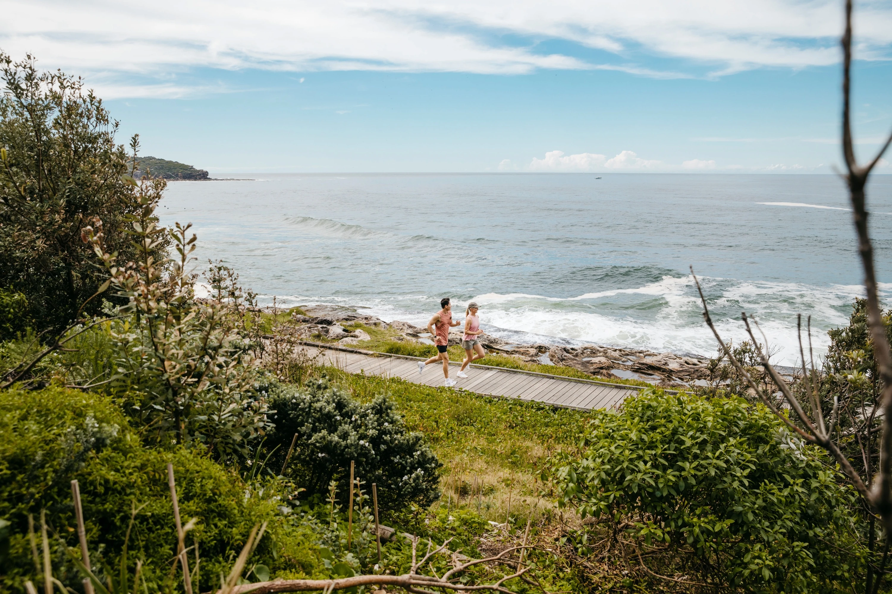 Friends enjoying a coastal run at Freshwater Beach