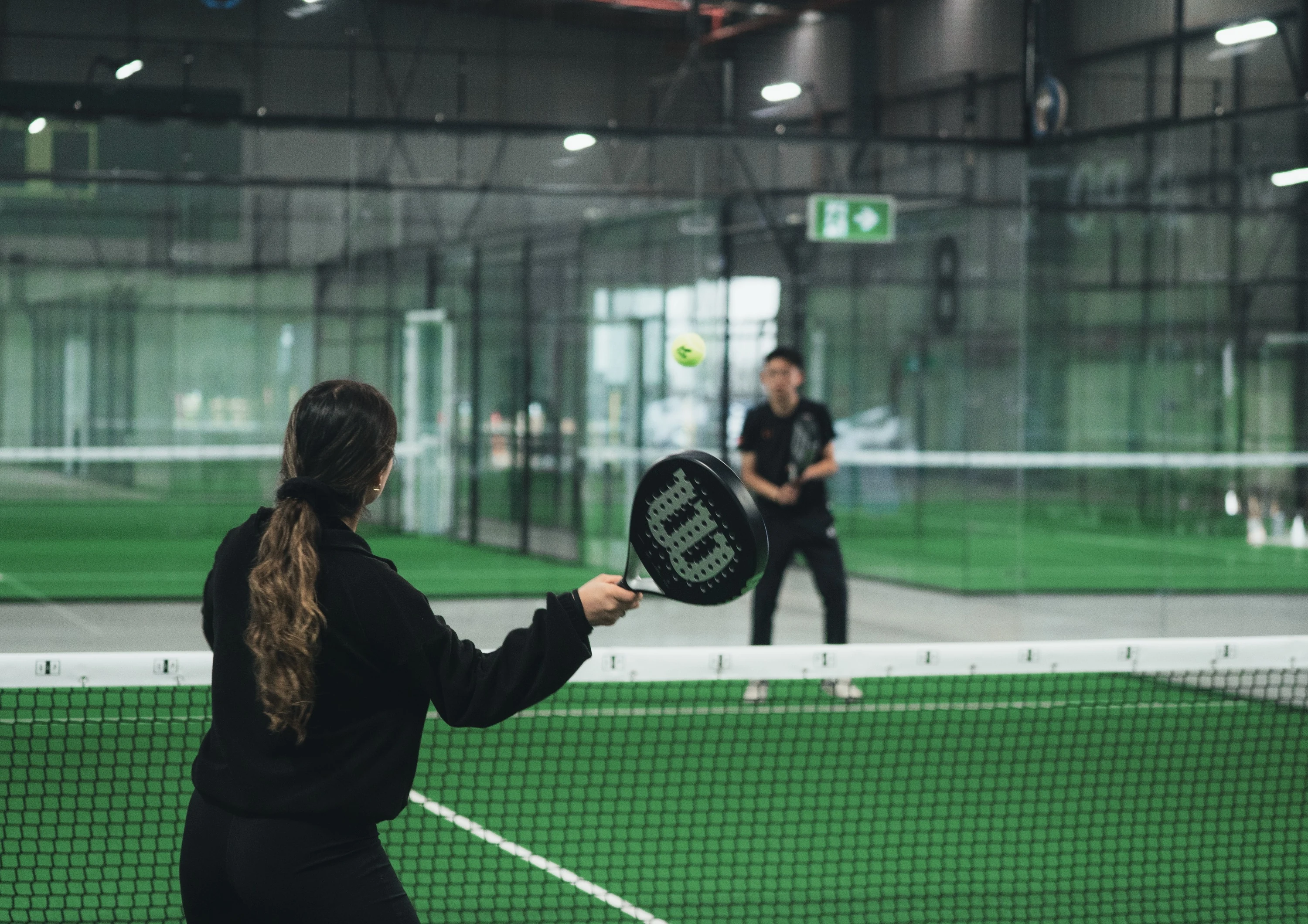 two women playing padel