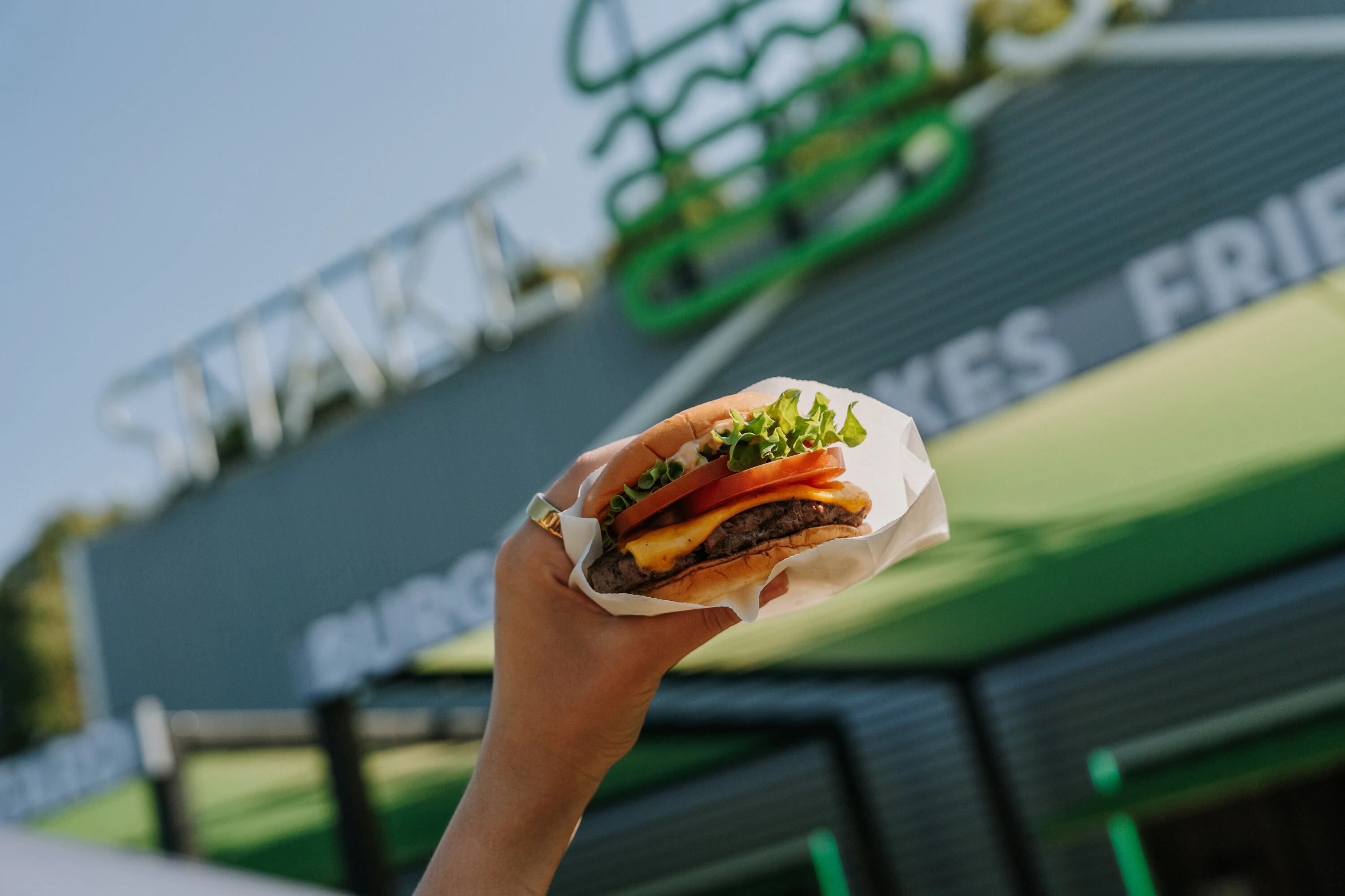 A hand holding a Shake Shack burger