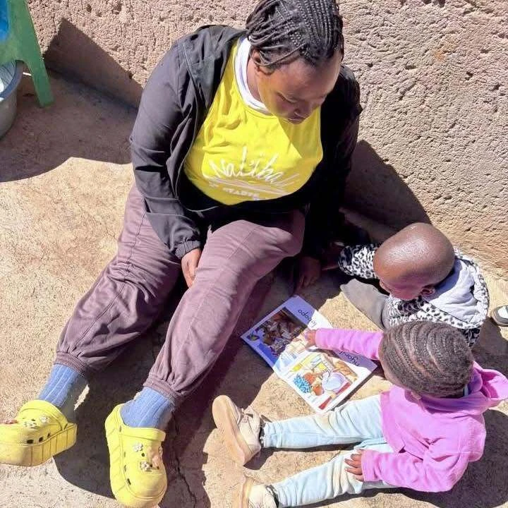 A parent reading a book with her children