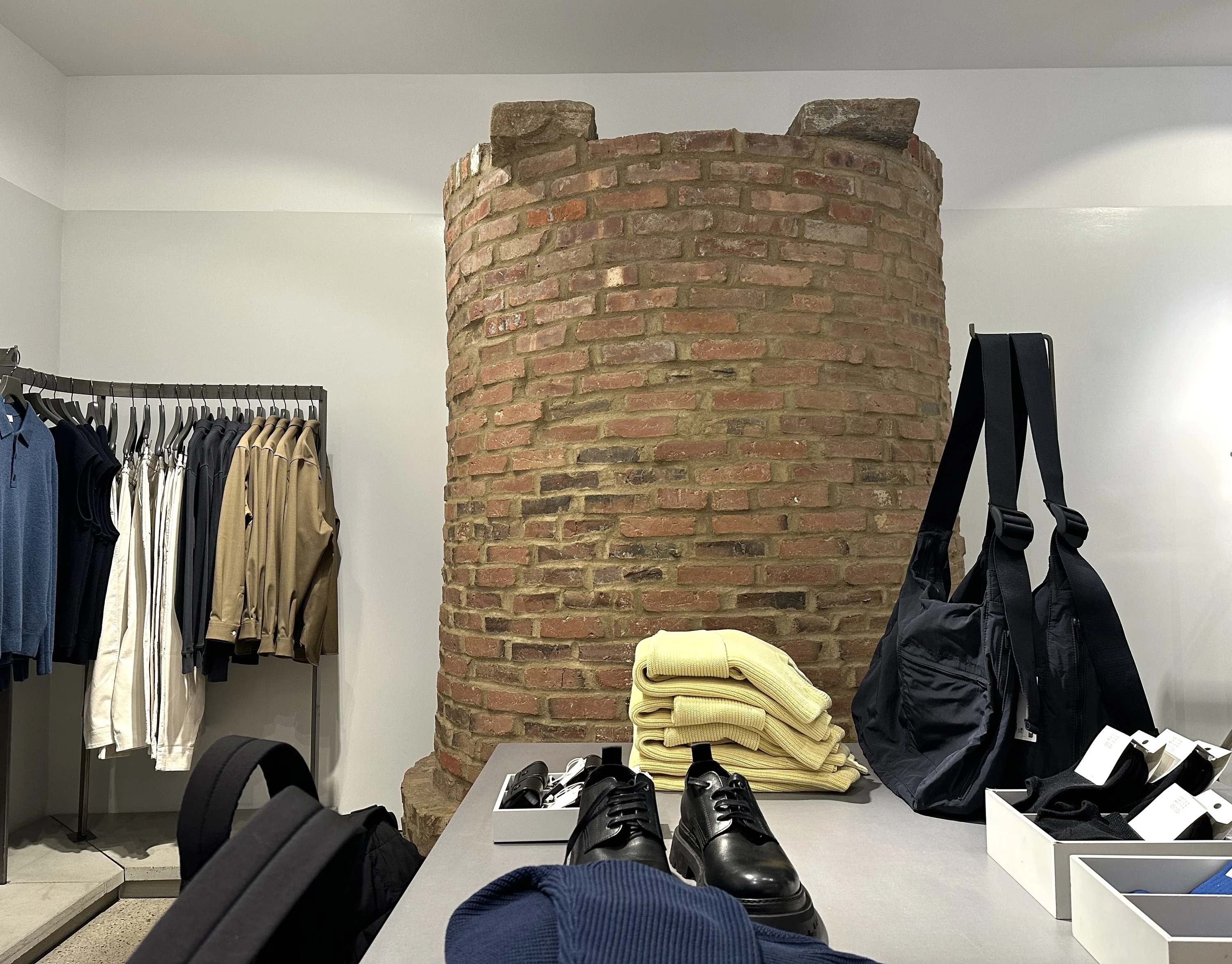 A brick well in the background of a clothing store.