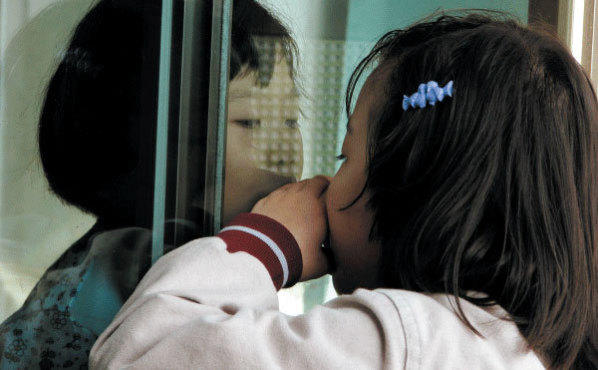 NO PANE, NO GAIN Kim Song-hee, left, peers through the window at her big sister