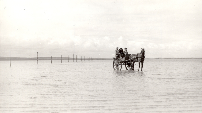 A mail cart is being driven across a shoreline bound for Holy Island, 1938.jpg