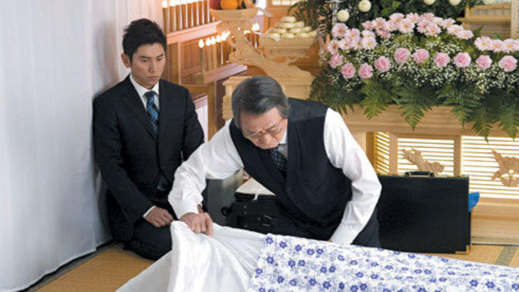 DEATH BECOMES YOU Motoki, left, learns from mortician Yamazaki.