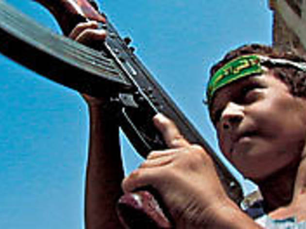 YOUTH BRIGADE An Iraqi child hoists his father's AK-47 YOUTH BRIGADE An Iraqi child hoists his father's AK-47.