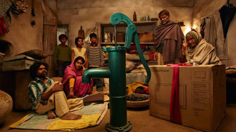 PUMP IT UP Manikpuri, left, and his neighbors admire a new household addition.