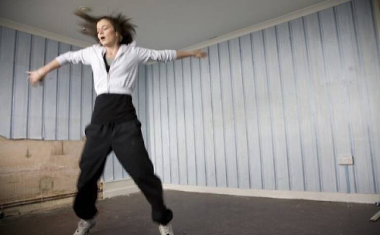 A still from the film Fish Tank of a teenage girl jumping in an empty room