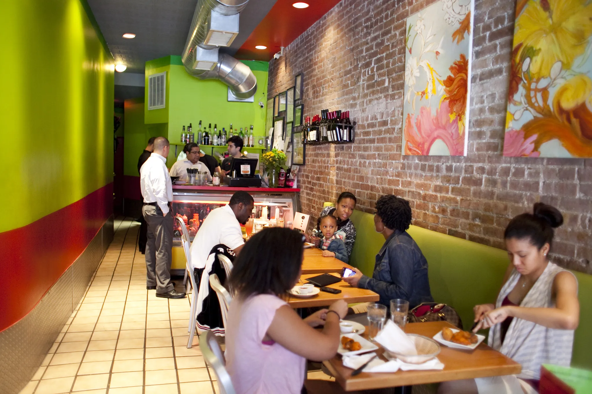 People eat empanadas inside a colorful restaurant.