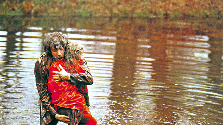 A still from the film Don't Look Now of a father carrying his drowned daughter from a lake