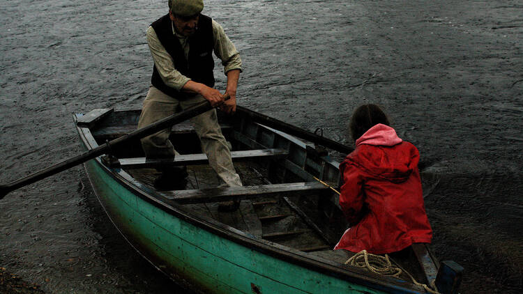 An elderly Chilean and his granddaughter row down the river in Patagonia Rising