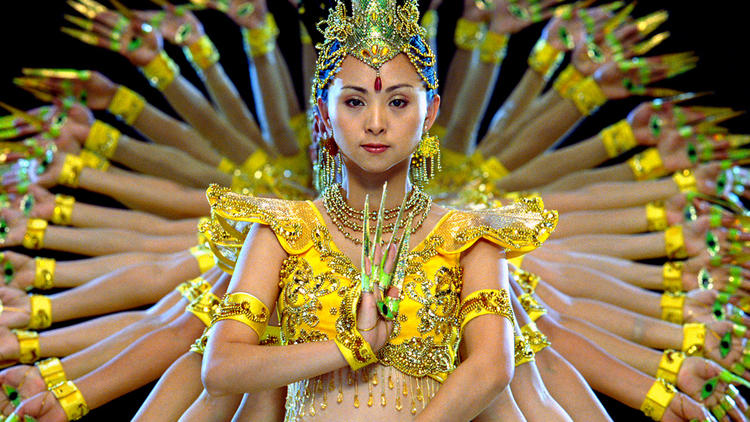 Chinese dancers throw their hands in the air in Samsara