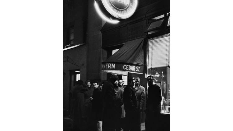 A group of patrons stands around on the sidewalk under the neon sign of the Cedar Street Tavern, Univeristy Place, Greenwich Village, New York, 1959