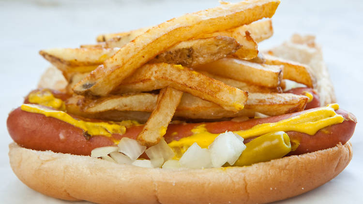 A hot dog topped with fries.