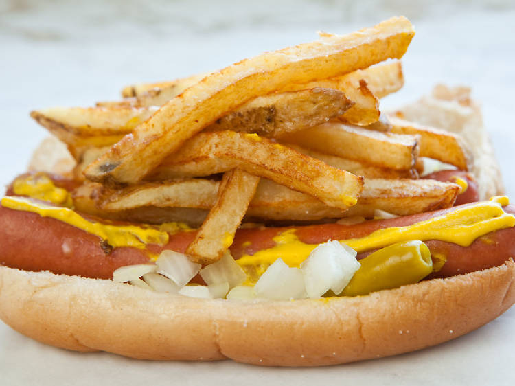 A hot dog topped with fries.