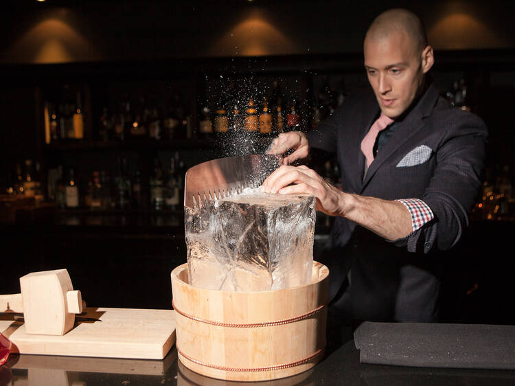 Michael Simon cutting down ice cubes at Charcoal bar. 