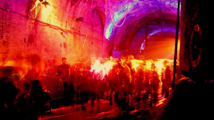 A photo of a party in a tunnel with disco lights.