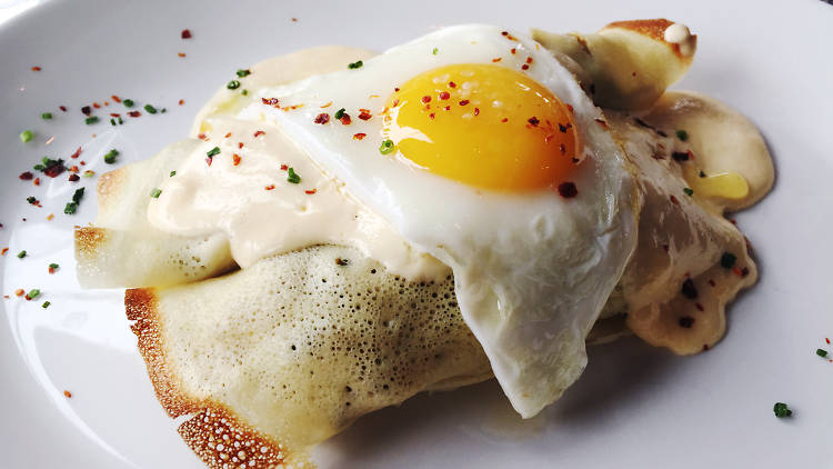 A10's brunch menu includes veggie crepes topped with cheese sauce and a fried egg.