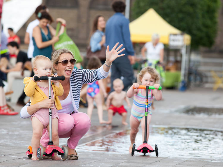 A family plays in Granary Square fountains, london