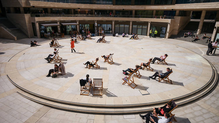 Londoners recline in deckchairs in Broadgate Circle, near Liverpool Street, London.