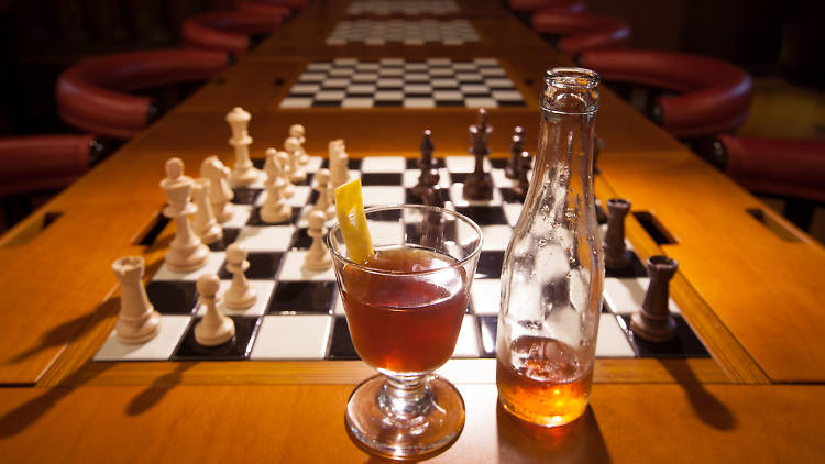 Beer and cocktail in front of chess game board