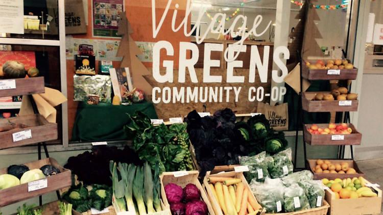 The Village Greens grocery wondow with lots of fresh vegetable produce