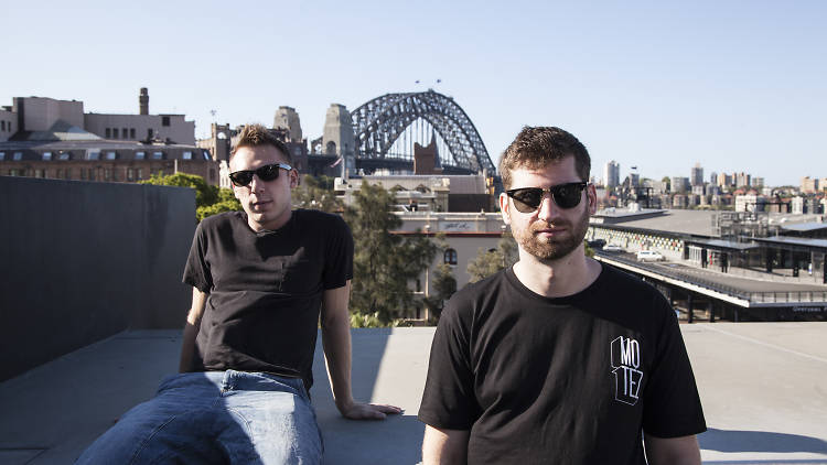 Clayton Knight and Harrison Mills of Odesza sit in front of Harbour Bridge