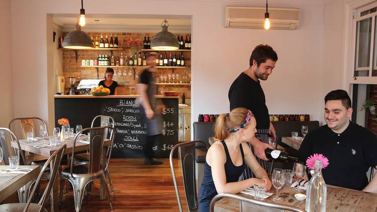 An interior shot at Sagra showing tables, customers being waited