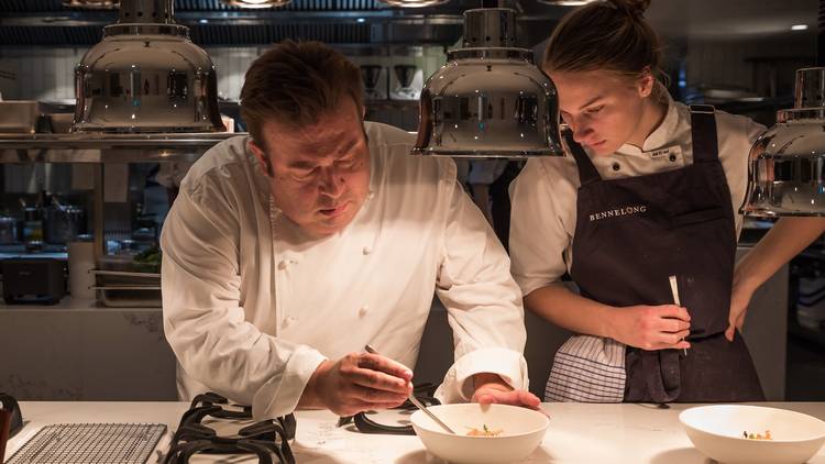 A shot of Peter Gilmore in the kitchen preparing a dish at Benne