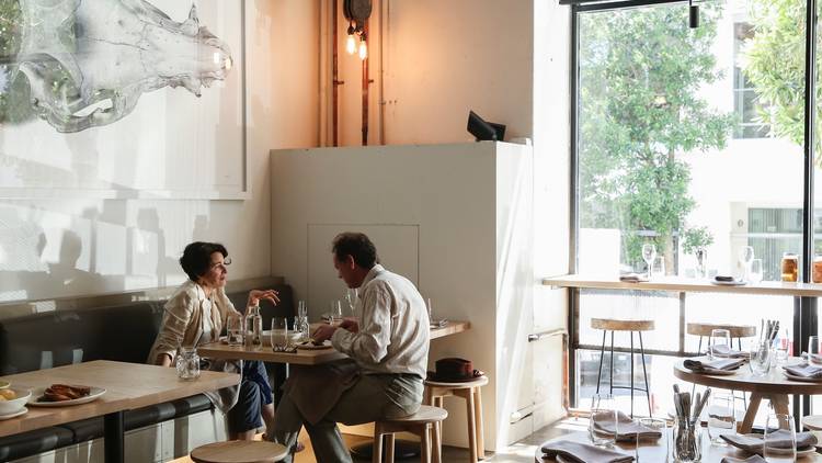 An interior shot at Nomad showing a couple sitting at a table ea