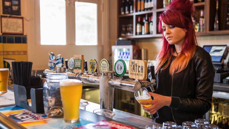 A shot of a bartender behind the bar at The Lord Gladstone, pull