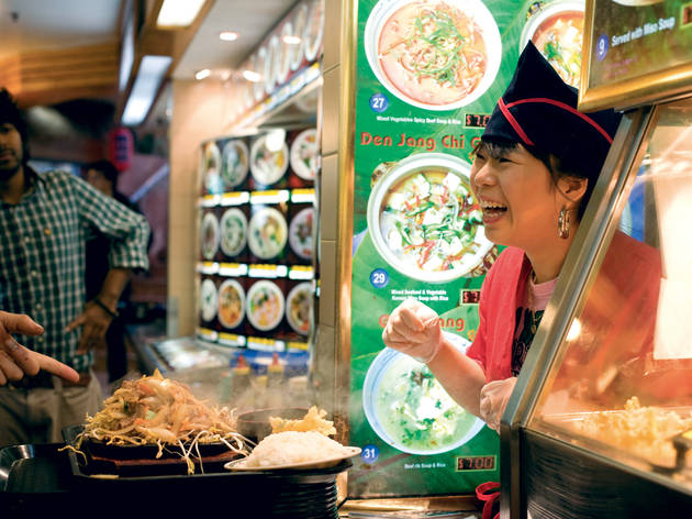 Woman in Chinatown Woman serves up a Chinese dish to a customer