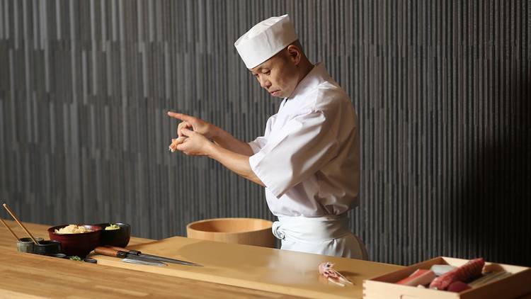 A shot of chef Koichi Minamishima behind the counter preparing f
