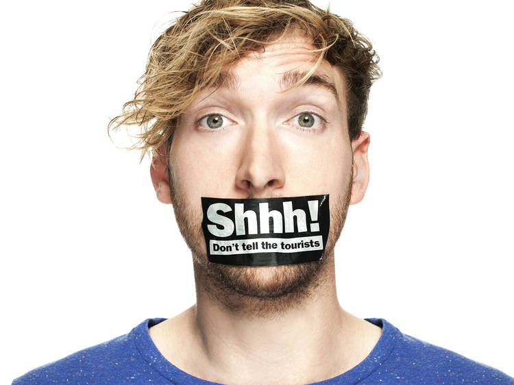 A man against a white background with duct tape over his mouth w