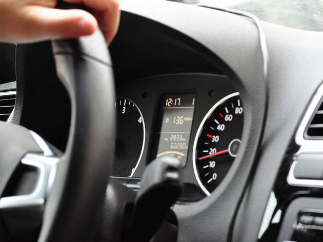 Hand on steering wheel A close up of a car's dashboard
