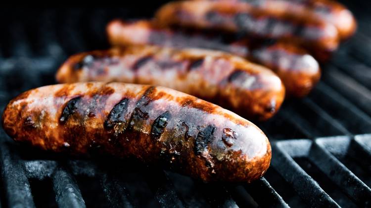 A generic barbecue close up shot of five sausages on a grill