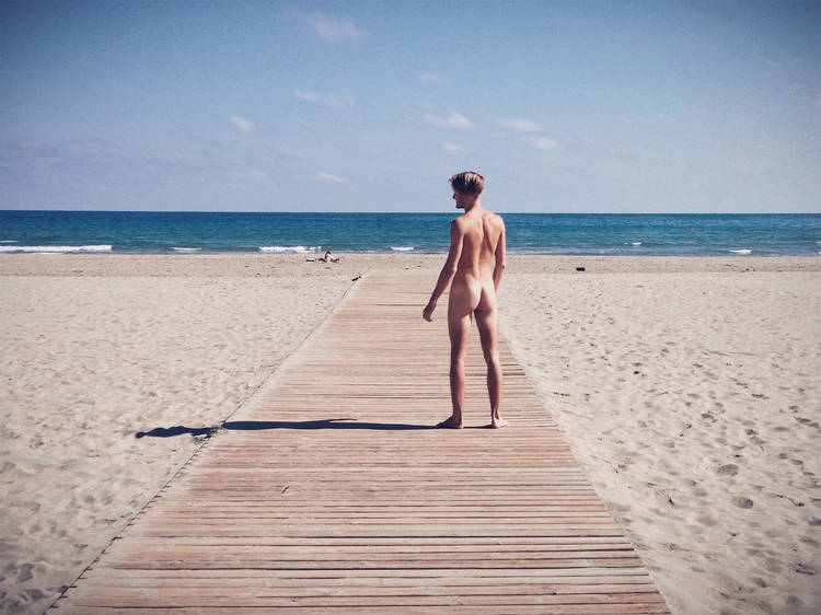 A generic image of a naked man on a beach looking out into the o