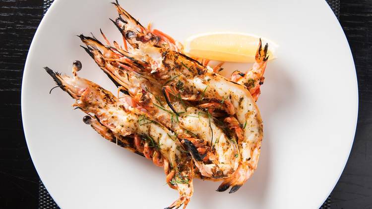 Charred prawns served with a lemon wedge