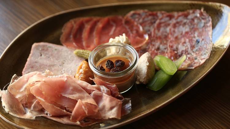 A close up shot of a charcuterie board full of cold sliced deli