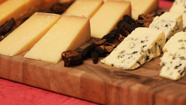 A close up shot of various cheese on a wooden board