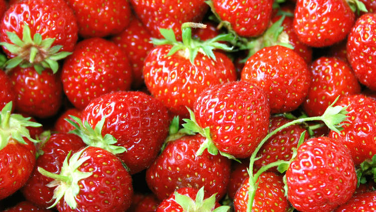 A top down close up shot of a bunch of bright red strawberries
