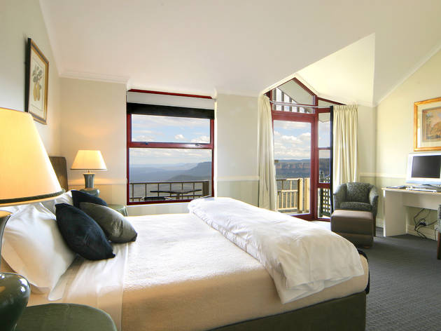 Guest room at Echoes Hotel A shot of a guest room with a bed and window view of the Blue Mountains at Echoes Hotel