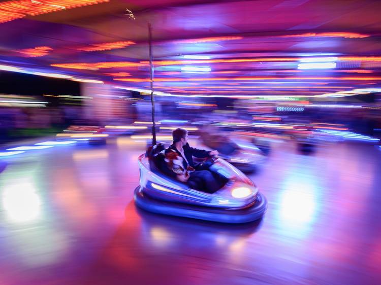 A motion shot of a bumper car driving around the arena